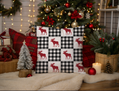 Decorative pillow with moose pattern in front of a Christmas tree