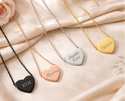 Heart-shaped necklaces with engraved text on a soft fabric background