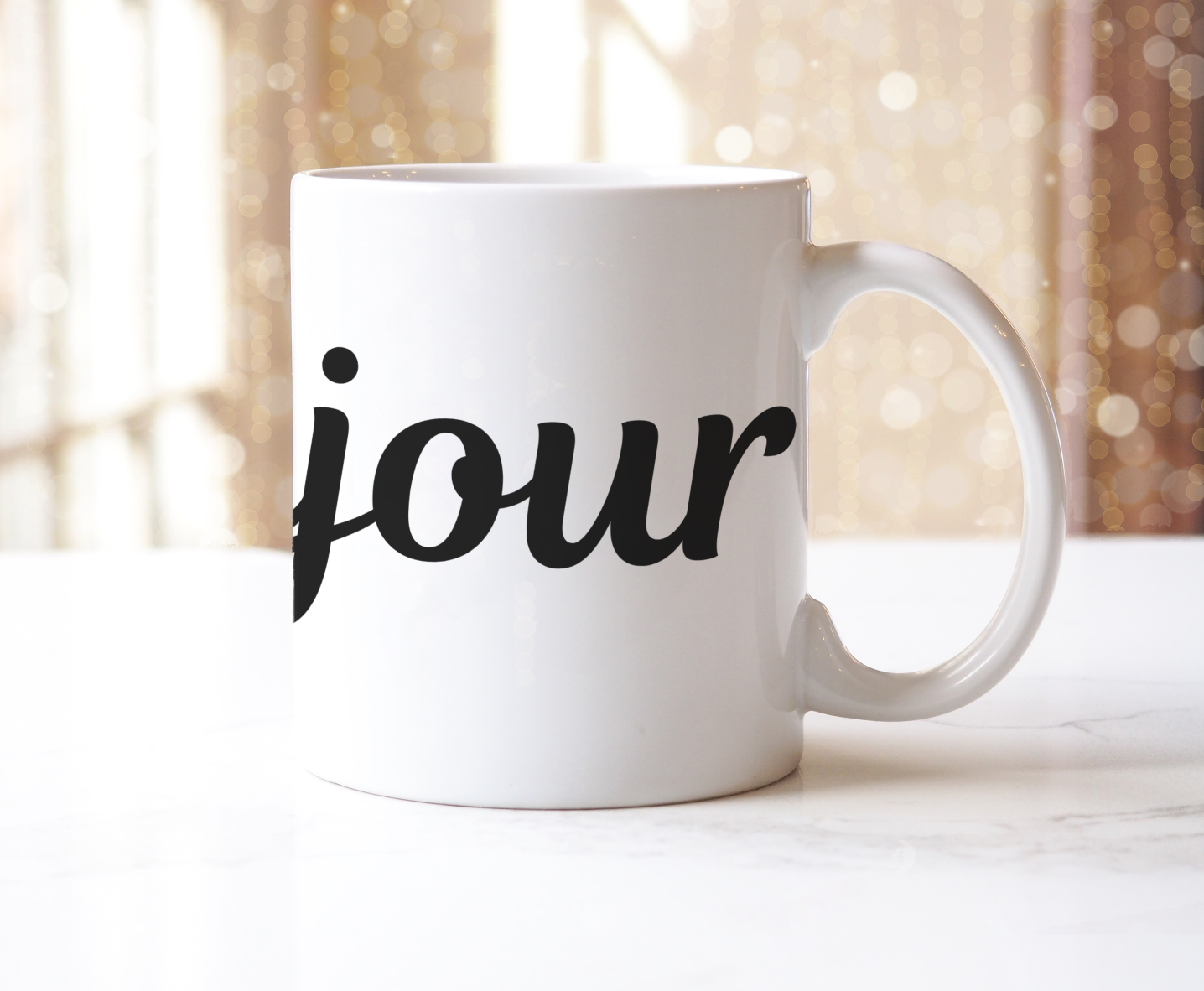 White mug with 'bonjour' printed on it against a blurred background