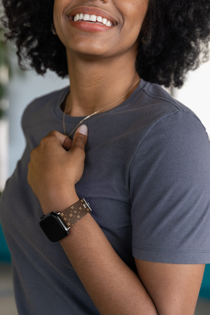 Person wearing a smartwatch with a brown and beige geometric print -blurred background